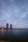 Landscape of coastline with skyscrapers against dusk sky — Stock Photo