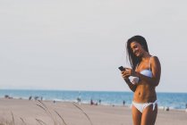 Bruna felice utilizzando il telefono cellulare — Foto stock