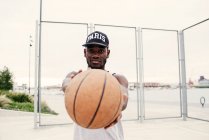 Negro hombre extendiendo baloncesto - foto de stock
