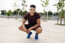 Joven deportista posando en cuclillas - foto de stock
