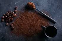 Кавові зерна і мелена кава на темряві — стокове фото