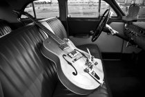 Oldtimer-Gitarre auf einem Autositz — Stockfoto