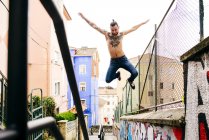 Homem sem camisa em movimento sobre fundo urbano — Fotografia de Stock