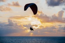 Silhueta com paraquedas sobre a paisagem marinha — Fotografia de Stock