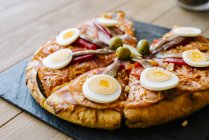 Pizza in Scheiben geschnitten mit Eiern — Stockfoto