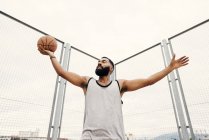 Confident man posing with basketball — Stock Photo