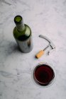 Червоне вино і келих на мармуровому столі — стокове фото