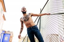 Sem camisa tatuado homem posando — Fotografia de Stock