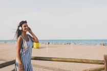 Жінка слухає музику на пляжі — стокове фото