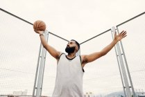 Selbstbewusster Mann posiert mit Basketball — Stockfoto