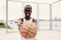 Preto homem estendendo basquete — Fotografia de Stock