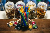 Straws and candies on counter — Stock Photo