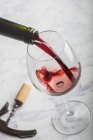 Servir du vin rouge en verre sur une table en marbre — Photo de stock