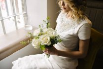 Woman sitting with bouquet — Stock Photo