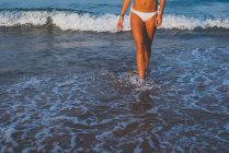Donna che cammina in riva al mare — Foto stock