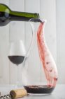 Despejando vinho tinto de uma garrafa para um decantador — Fotografia de Stock