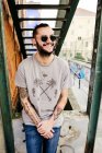 Homme hipster souriant sur fond urbain — Photo de stock