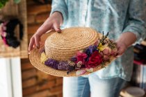 Mujer de la cosecha sosteniendo sombrero decorado - foto de stock