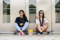 Стильні підлітки з попкорном на ковзанах — стокове фото