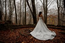 Jeune belle mariée en robe de mariée dans la forêt d'automne — Photo de stock