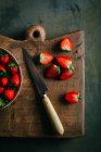 Cutting strawberries on cutting board — Stock Photo