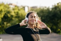 Zufriedene Mädchen hören draußen Musik — Stockfoto