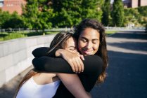 Fröhliche Mädchen, die sich im Park umarmen — Stockfoto