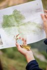 Frauenhand mit Kompass über Landkarte — Stockfoto