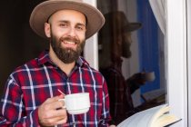 Stylish male with coffee and book — Stock Photo