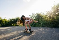 Teenager fahren Skateboard im Sonnenlicht — Stockfoto