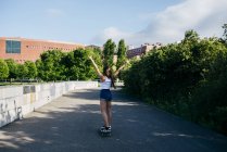 Возбужденная девушка на коньках в парке — стоковое фото