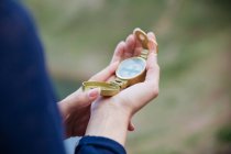 Close up vista de bússola dourada na mão feminina — Fotografia de Stock