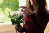 Beautiful female holding roses — Stock Photo