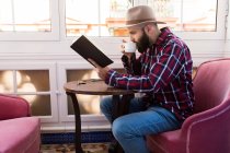 Молодий чоловік з книгою в кафе — стокове фото