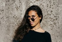 Chica de moda mirando sobre gafas de sol - foto de stock