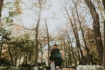 Seitenansicht eines romantischen Paares, das sich im Park umarmt — Stockfoto