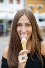 Портрет красивой молодой женщины, лизающей рожок мороженого — стоковое фото