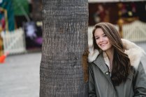 Молодая девушка в теплой одежде возле дерева — стоковое фото