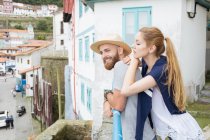 Girl looking over mans shoulder to village — Stock Photo