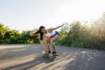Підліткові скачки скейтборд на сонячному світлі — стокове фото