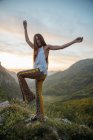 Portrait of brunette girl cheerfully posing at mountain countryside on sunny day — Stock Photo