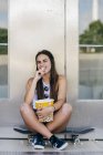 Очаровательная девушка с попкорном на роликах — стоковое фото
