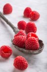 Raspberries on vintage spoon on marble table — Stock Photo