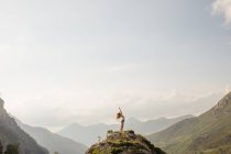 Femme posant sur le sommet de la montagne contre un ciel incroyable — Photo de stock