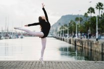 Молодая гимнастка в позе на набережной — стоковое фото