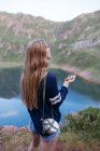Girl using compass at mountain lake — Stock Photo