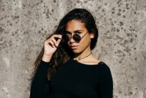 Trendy girl looking over sunglasses — Stock Photo