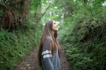 Menina sorridente na estrada da floresta — Fotografia de Stock