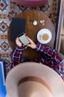 Homme en chapeau utilisant le téléphone à la table — Photo de stock