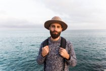 Stilvoller junger Mann posiert gegen das Meer — Stockfoto